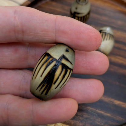 Korálek vypalovaný petroglyf pták